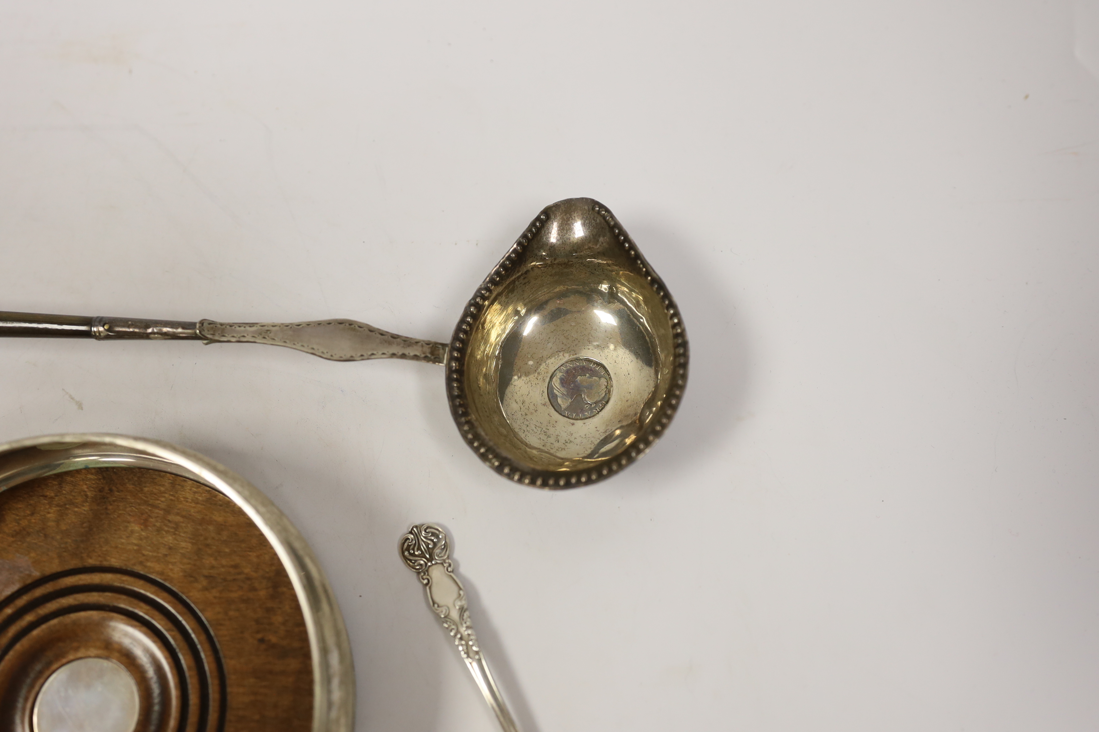 A modern silver mounted wine coaster, a silver sifter spoon, sterling cigarette case, silver tobacco box and a white metal toddy ladle with baleen handle.